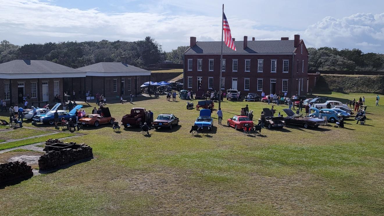 A group of cars parked in a field

Description automatically generated