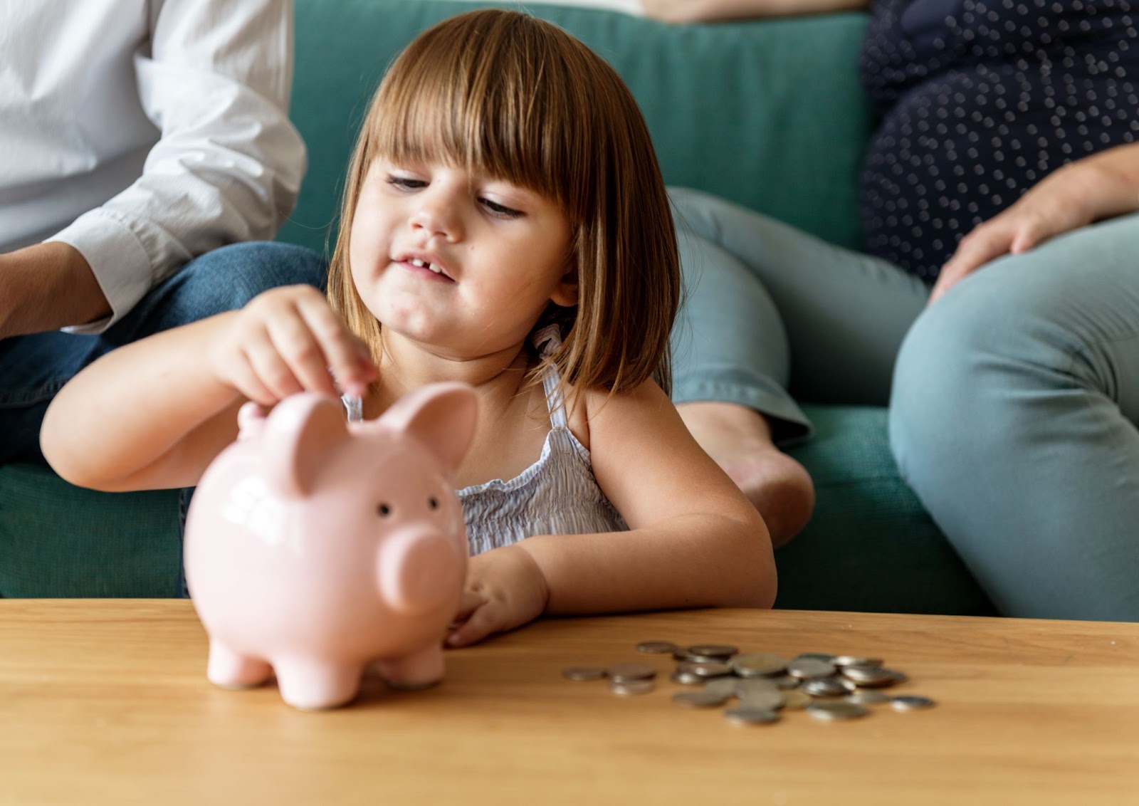 white girl with gap teeth investing coins in her piggy bank