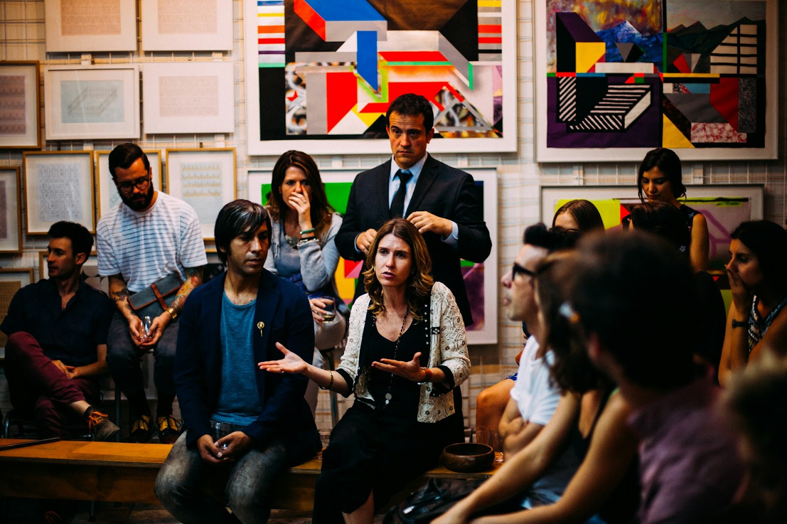 Diverse group in a vibrant art gallery discussing