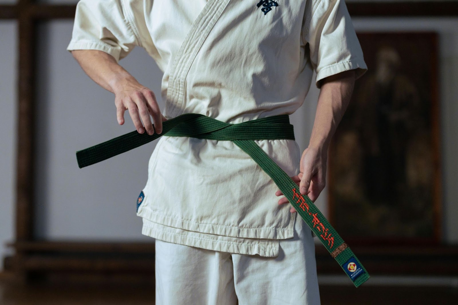 A martial arts student wearing a green belt