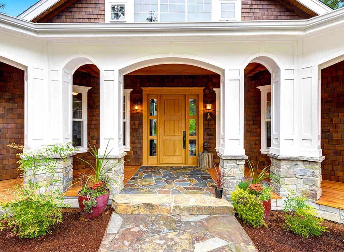 The entry porch with a wooden front door is framed with tapered columns.