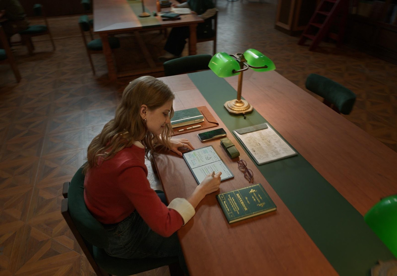 A person sitting at a desk writing on a book

Description automatically generated