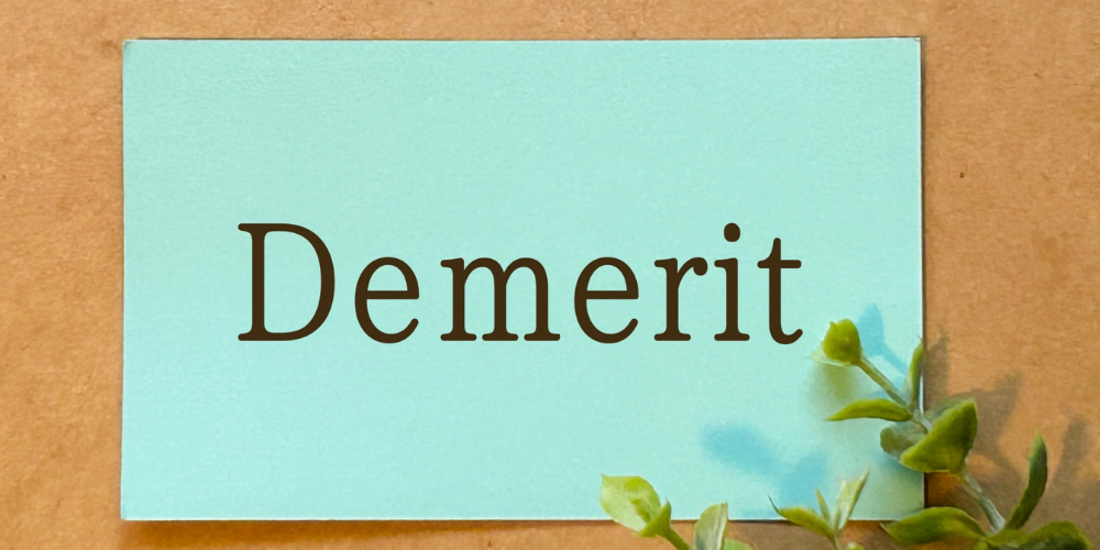 ミント色カードに「Demerit」と印字され、左下に観葉植物の葉がのぞくイメージ