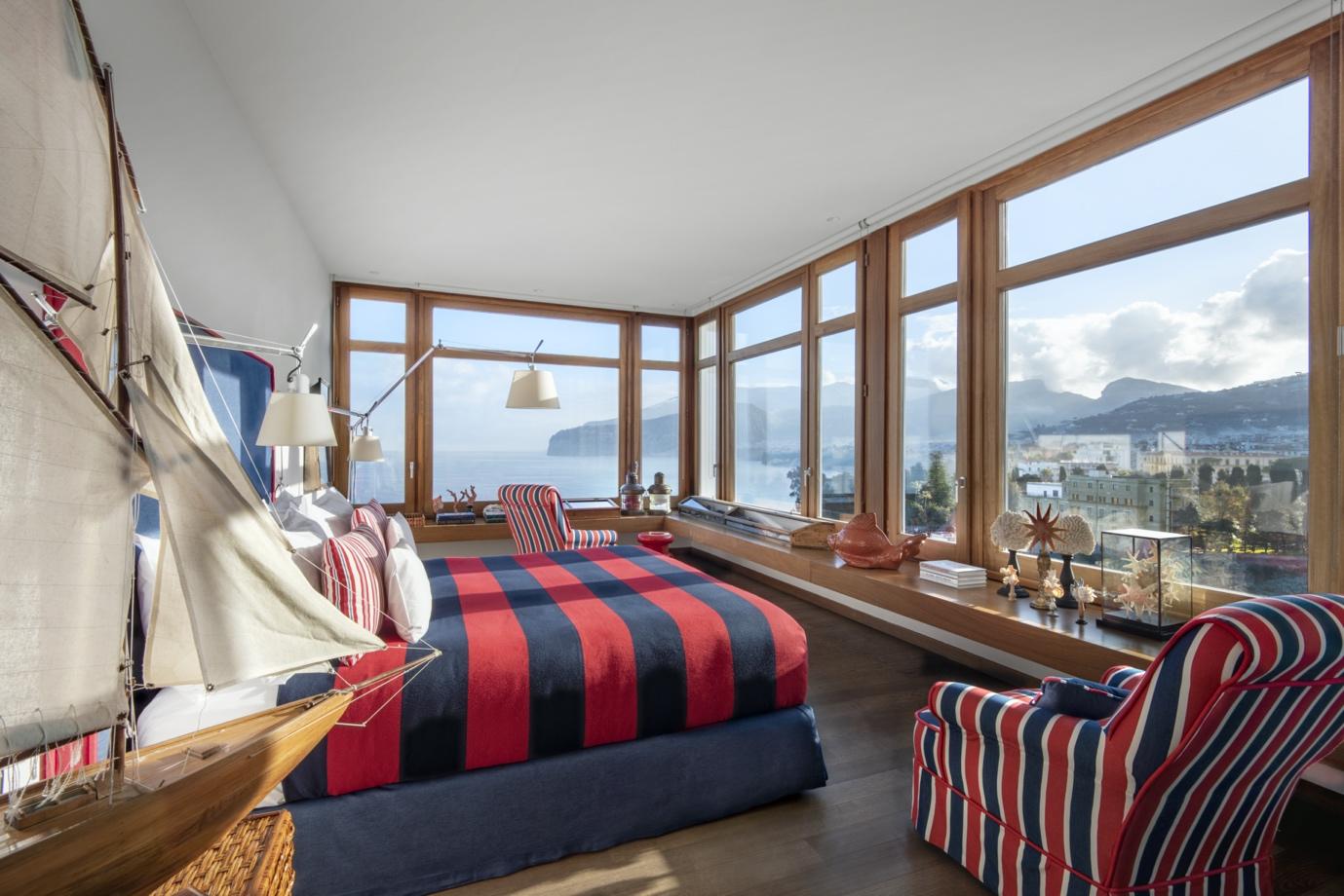 A room with a bed and chairs

Description automatically generated