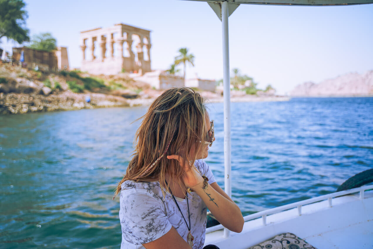 woman sailing on the nile with a museum behind her 