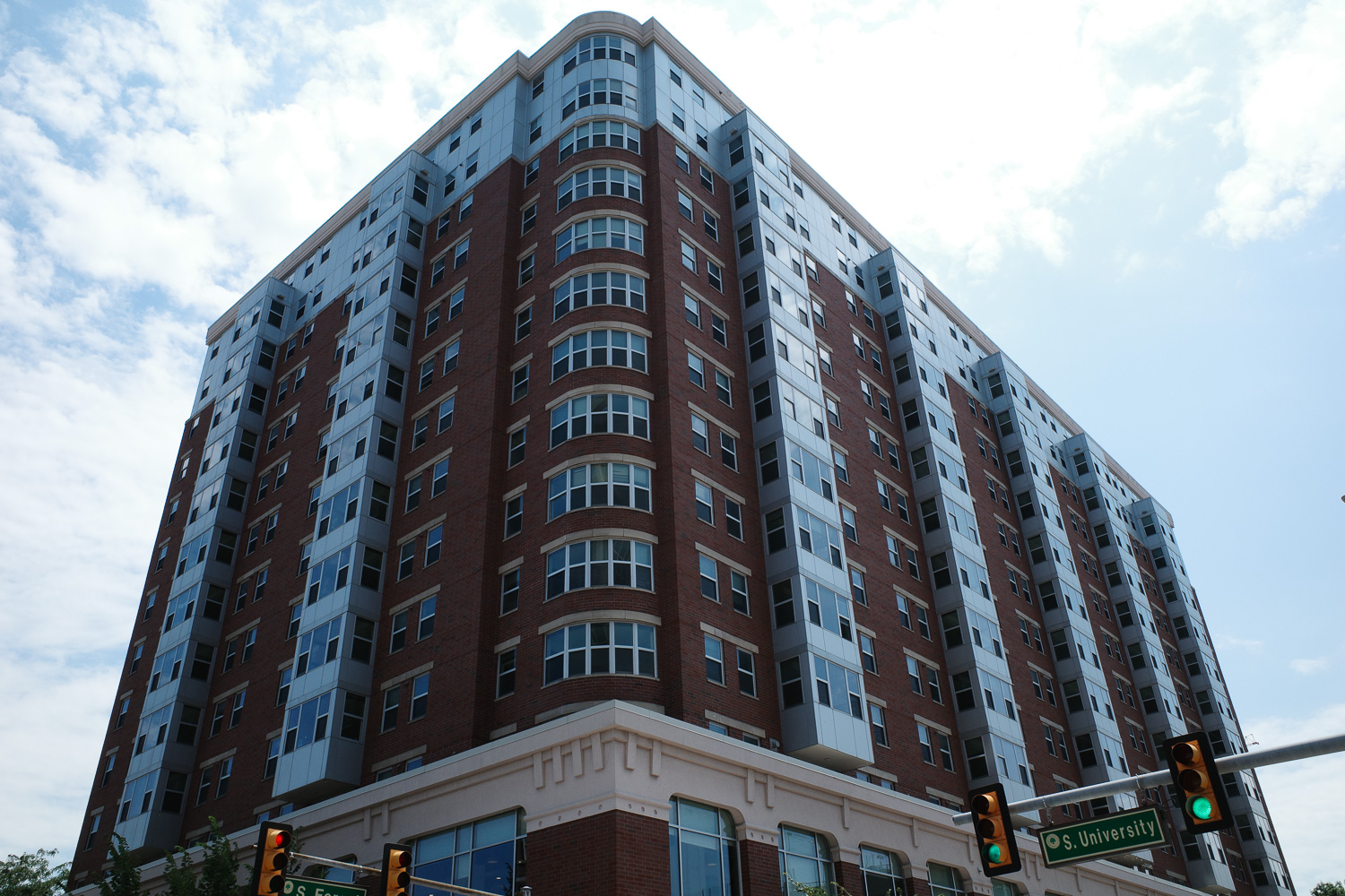 High rise apartment building with street sign reading "S. University"