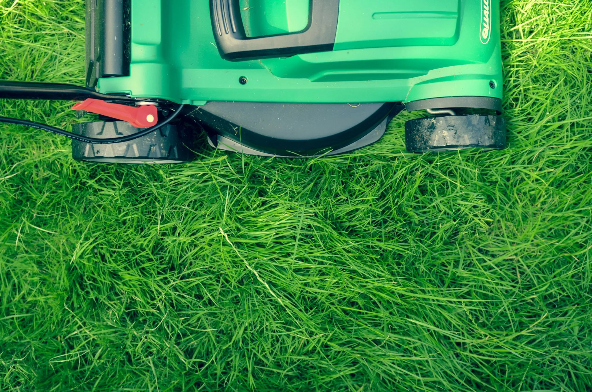 A modern lawn mower on a freshly cut lawn, showcasing its sleek design and efficiency for maintaining a well-manicured yard