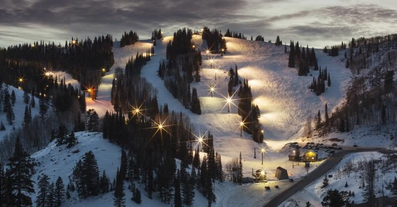 an image of powder mountains runs lit up at night