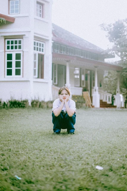 girl crouching on grass