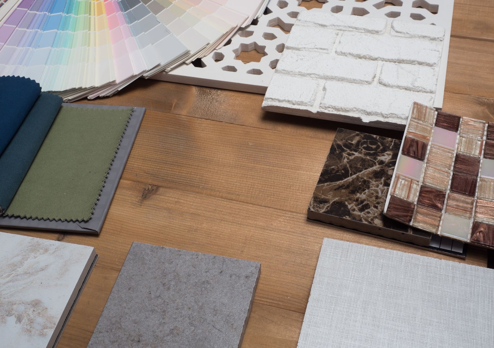  A close-up view of material samples for flooring, showcasing color swatches, and decorative tiles.