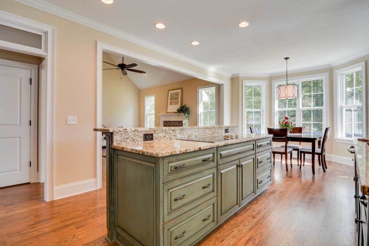 Across the kitchen island is the breakfast nook brightened by a stylish drum chandelier and bay window.