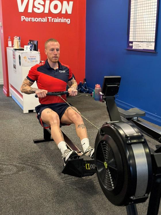 a Vision PT personal trainer using the rowing machine