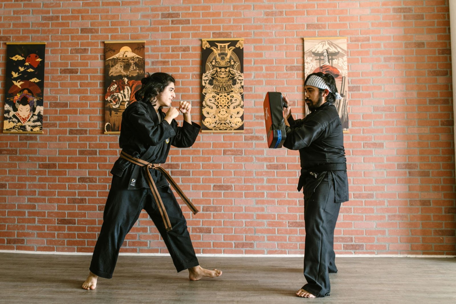 A martial arts instructor teaching a student how to strike