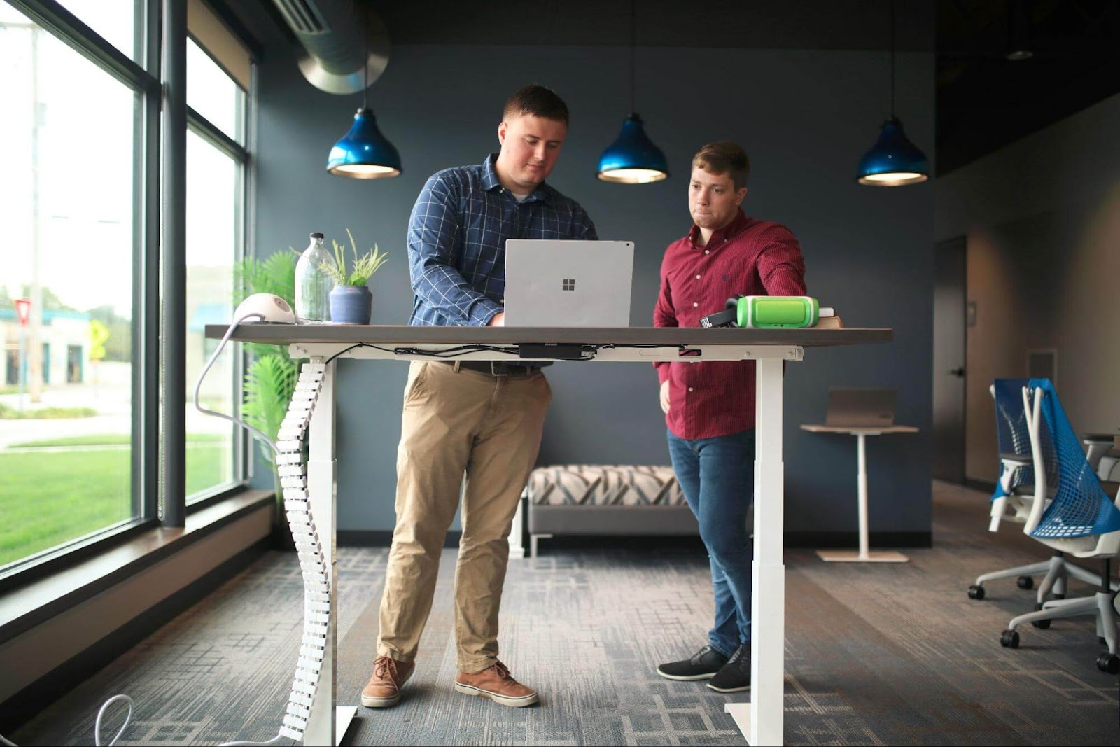 Two people working together at a standing desk