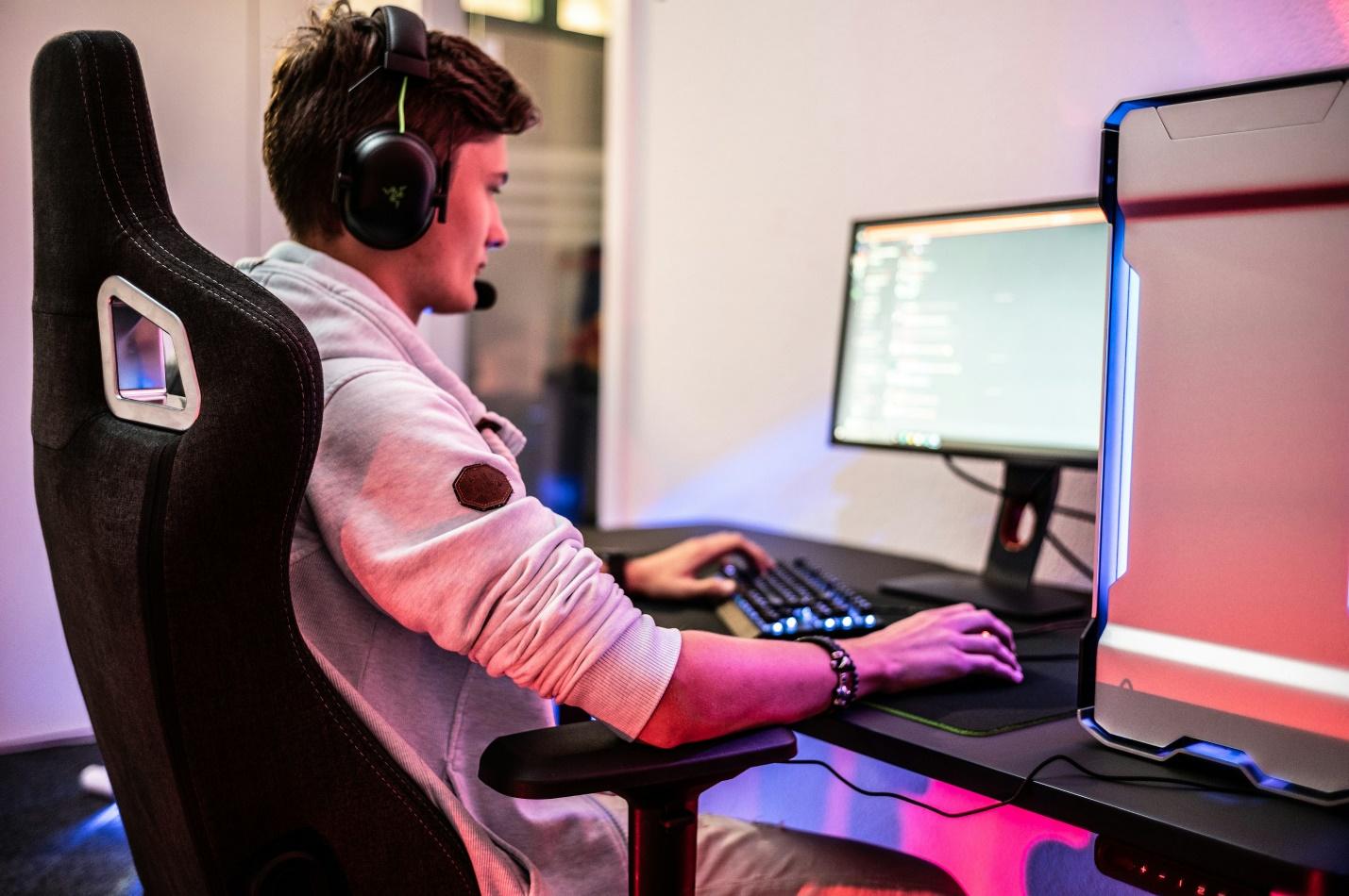 a man sitting in front of a computer with headphones on