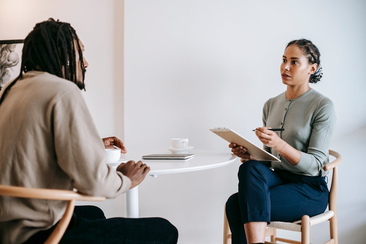 A woman sitting and speaking with a man