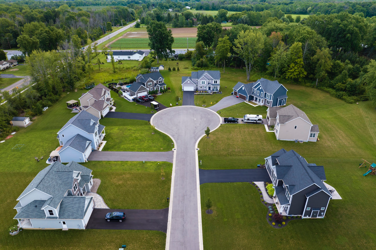 An aerial view of homes with asphalt driveways.