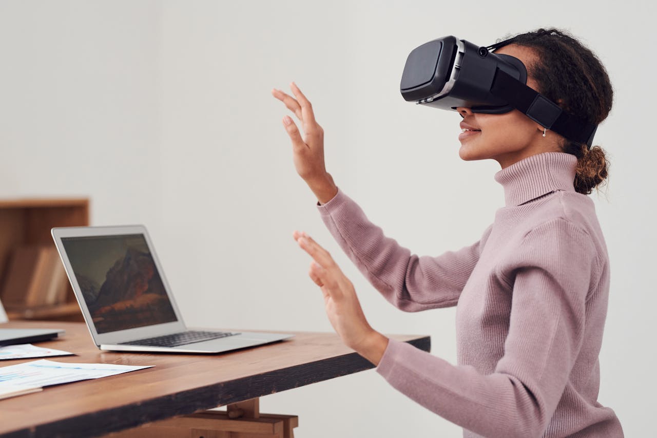 A woman with a VR Glasses infront of a laptop