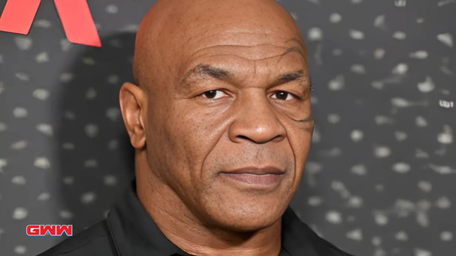 Mike Tyson posing with a serious expression at an event