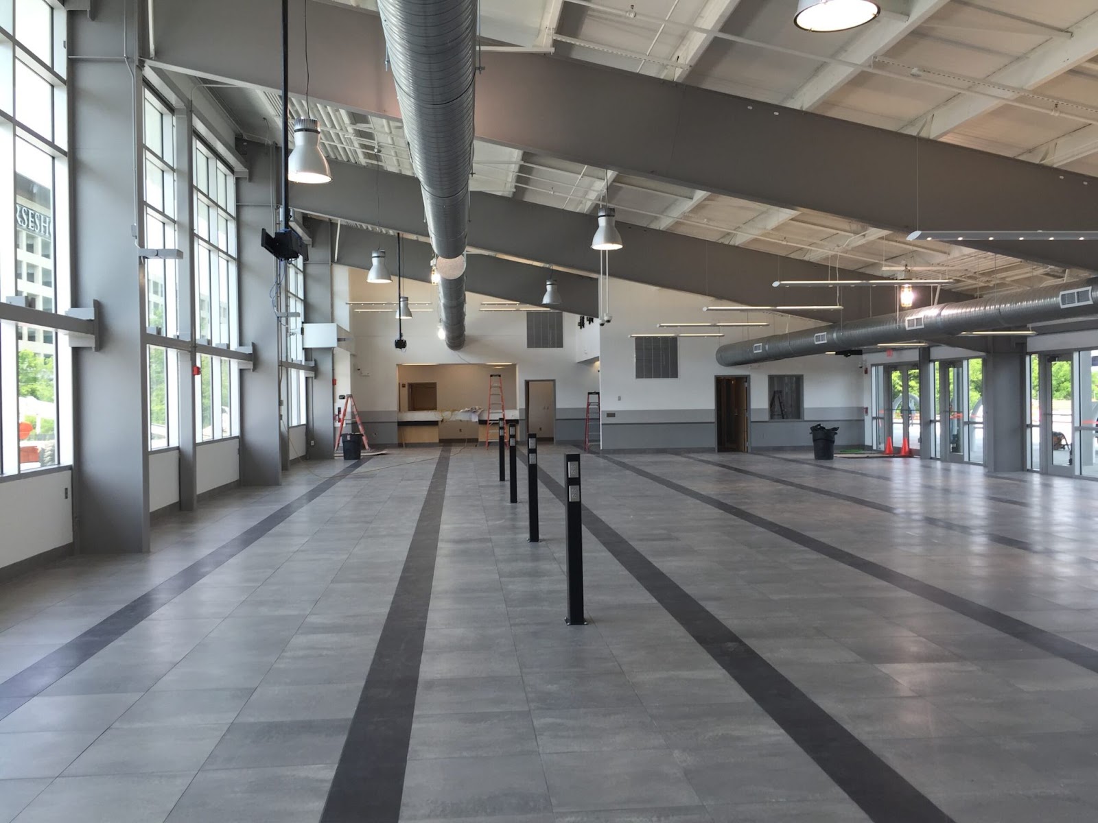 Greyhound Bus Terminal interior with large windows, industrial lighting, and a spacious tiled floor.
