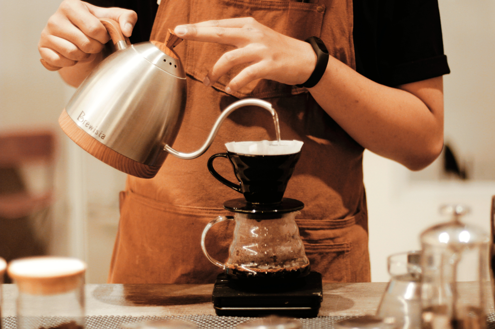 A barista using a Brewista Gooseneck Kettle for precise brewing control.