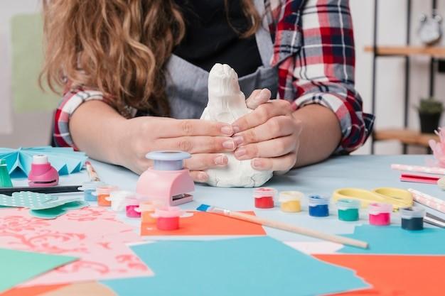 close-up of craftswoman kneading white clay on table, Picture