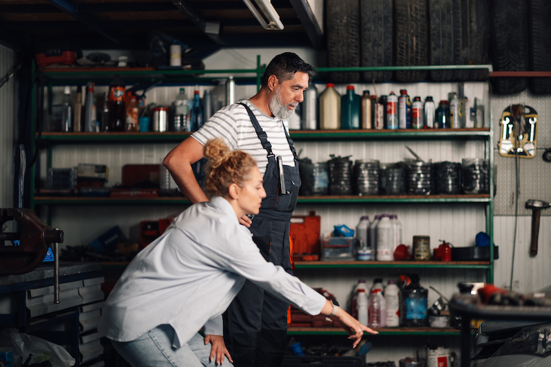 Staffing Strategies, woman showing vehicle issues to garage mechanic