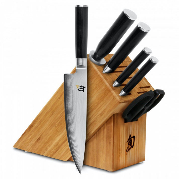 An image featuring the Shun Classic seven-piece knife block set on solid white background. This chef knife set includes a paring knife, a utility knife, a chef's knife, a bread knife, a honing steel, herb shears, and an 11-slot storage block.