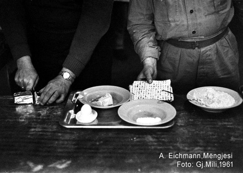 Served by a guard, Eichmann cuts breakfast margarine as matzos -- Jewish unleavened bread -- are put... VIEW MORE+.jpg