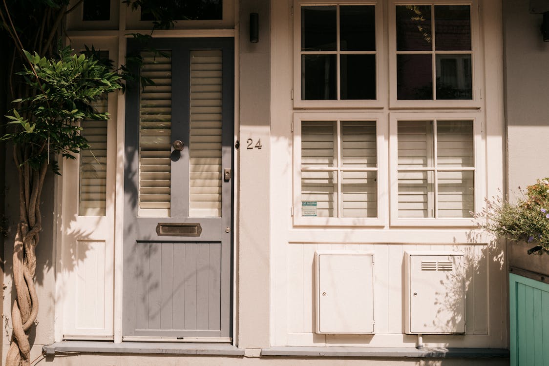 Free Close-up of a London home's facade featuring a charming white and grey door with shuttered windows. Stock Photo