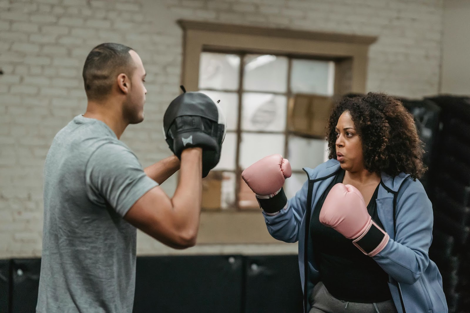 A woman training how to punch with her instructor