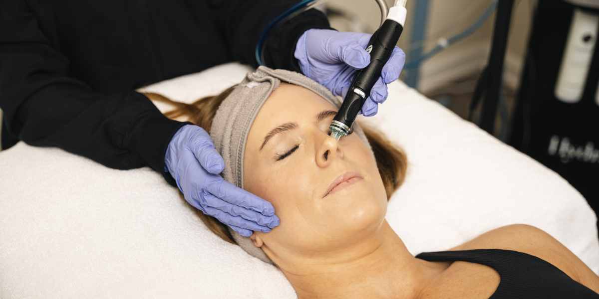 A woman receiving a Hydrafacial treatment in a salon, enjoying a multi-step facial for skin cleansing and hydration.