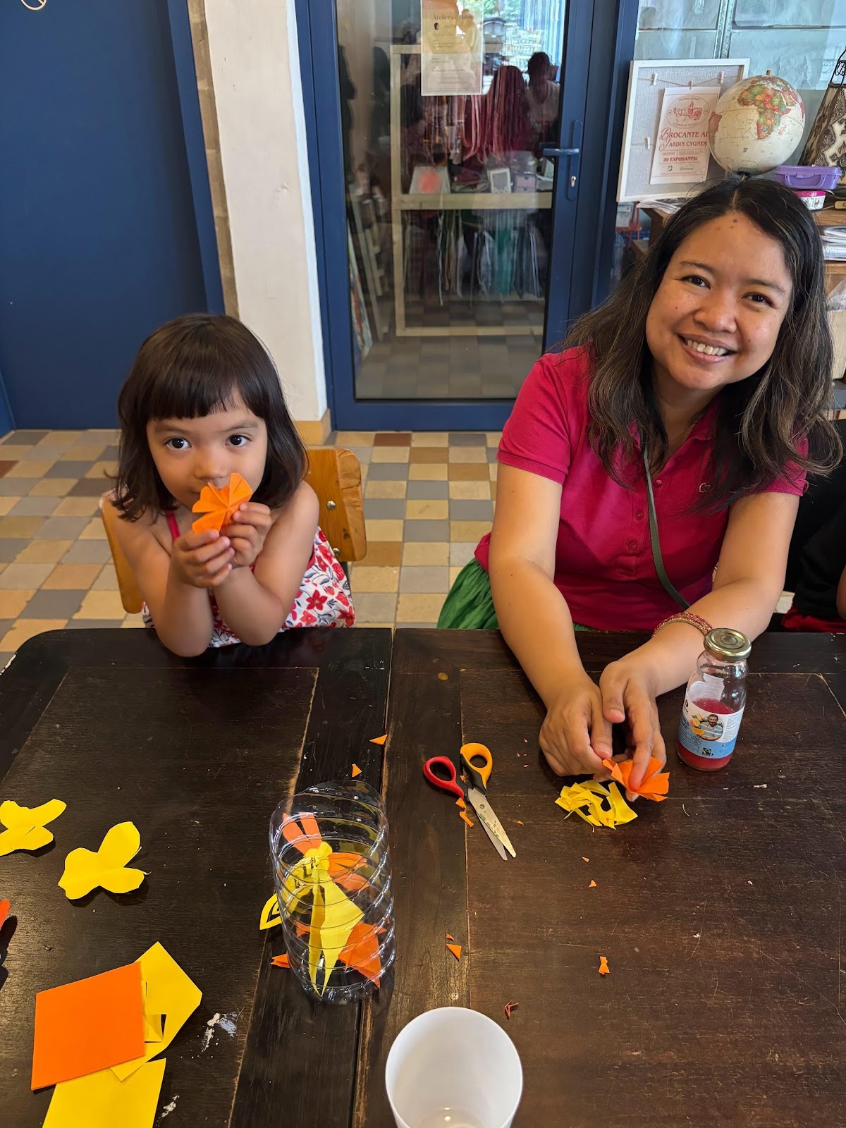 A person and a child making paper flowersAI-generated content may be incorrect.