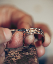 A person's hand holding a gold ring

AI-generated content may be incorrect.