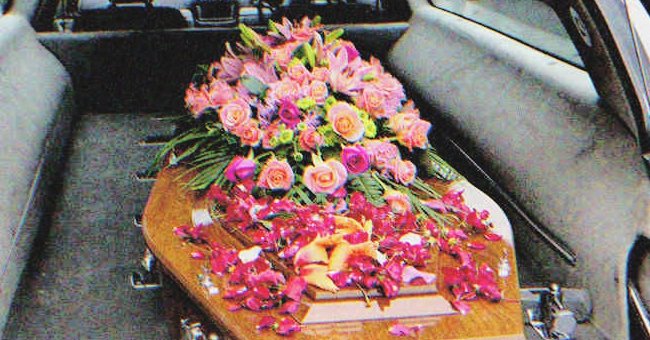 A coffin with flowers on it in a hearse | Source: Shutterstock