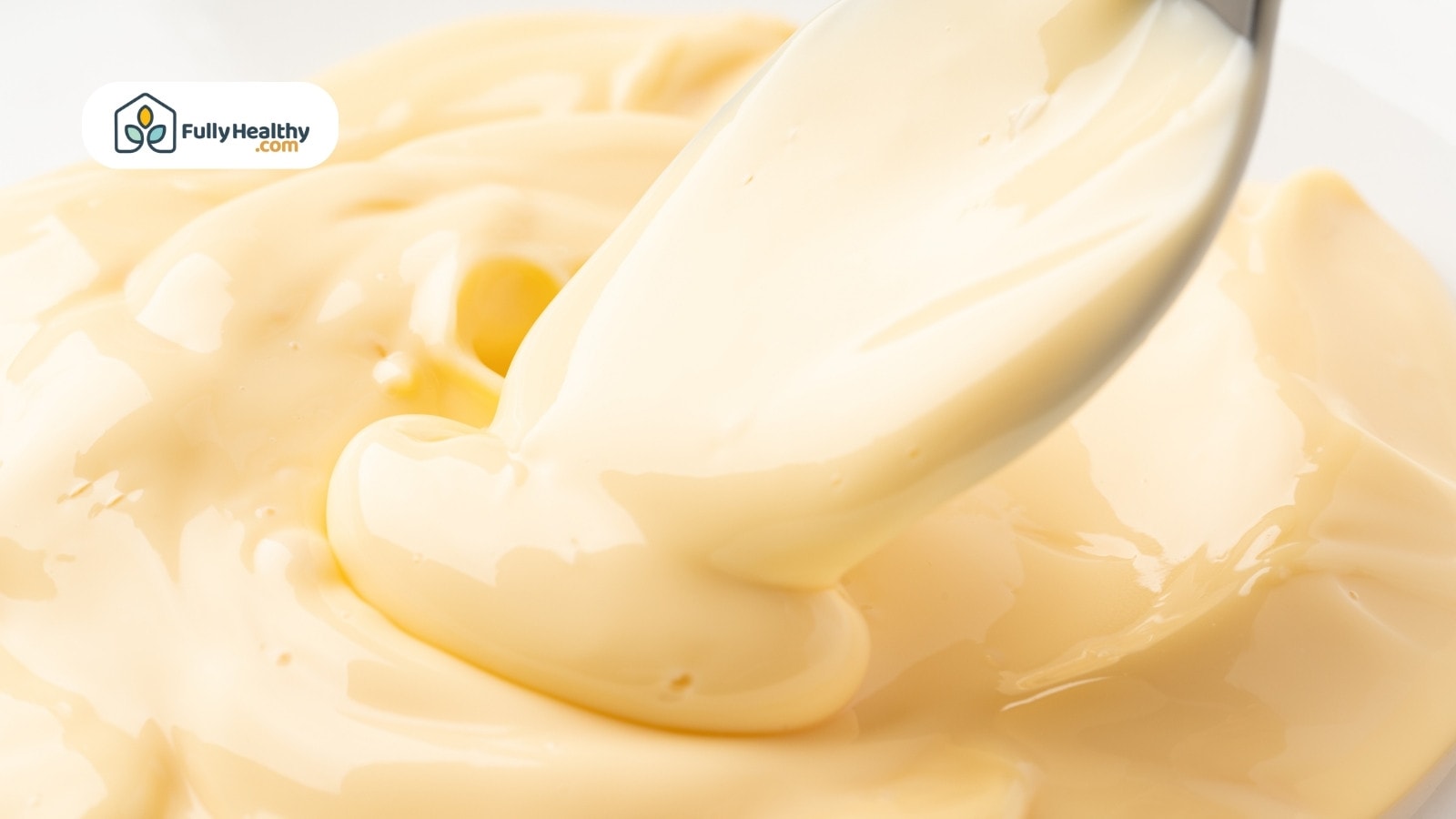 Close up of mayonnaise being scooped with metal spoon
