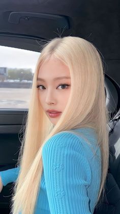 This contains an image of BLACKPINK Jennie with a blonde hair and wearing a blue sweater  