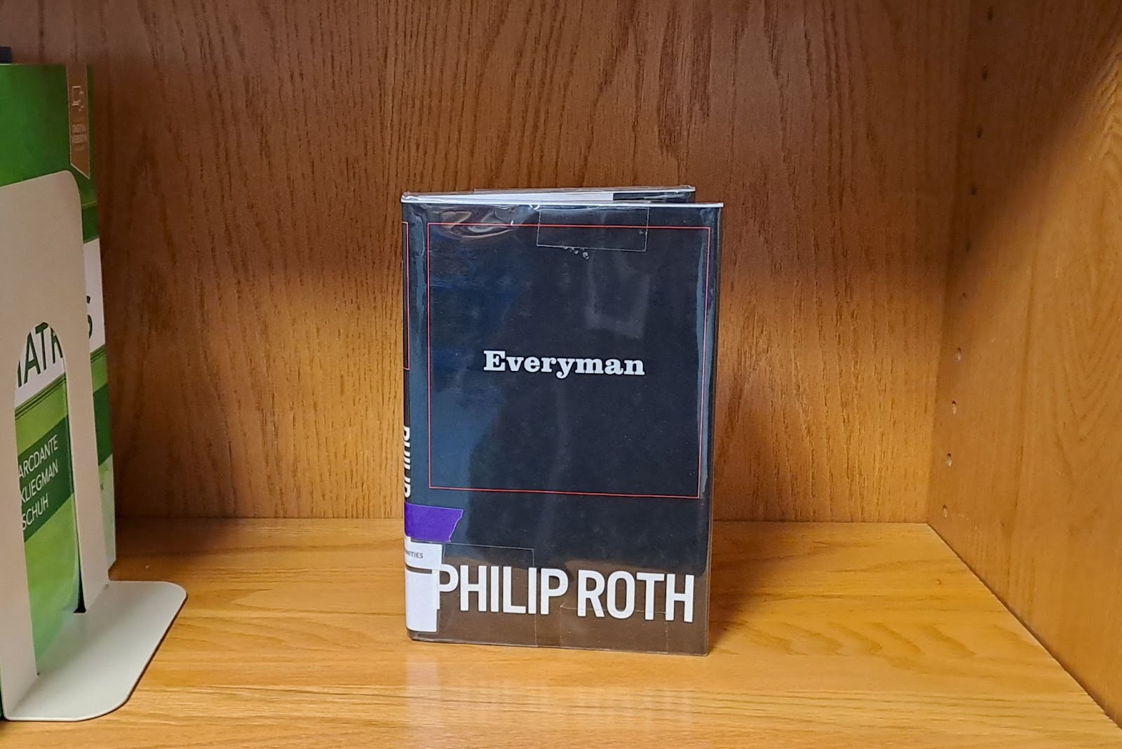 A copy of "Everyman" by Philip Roth sits on a shelf. 