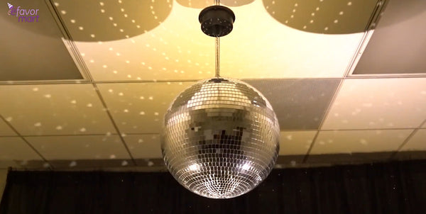 Disco ball reflecting light spots on ceiling, creating a sparkling ambiance.