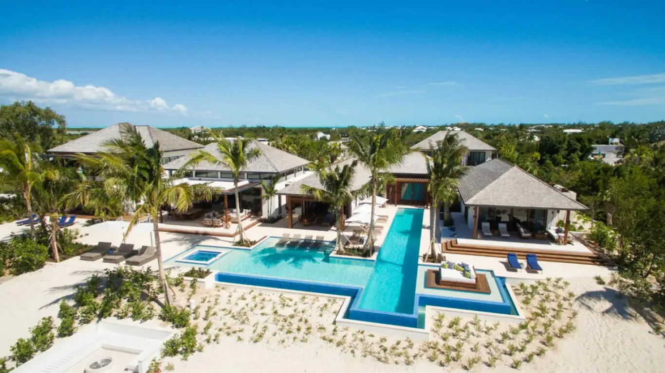 Exquisite beachfront estate - Hawksbill Estate Alt text: An opulent beachfront villa, Hawksbill Estate in Turks and Caicos, featuring multiple modern pavilions, a geometric infinity pool, and verdant tropical surroundings with direct access to white sand beaches. 