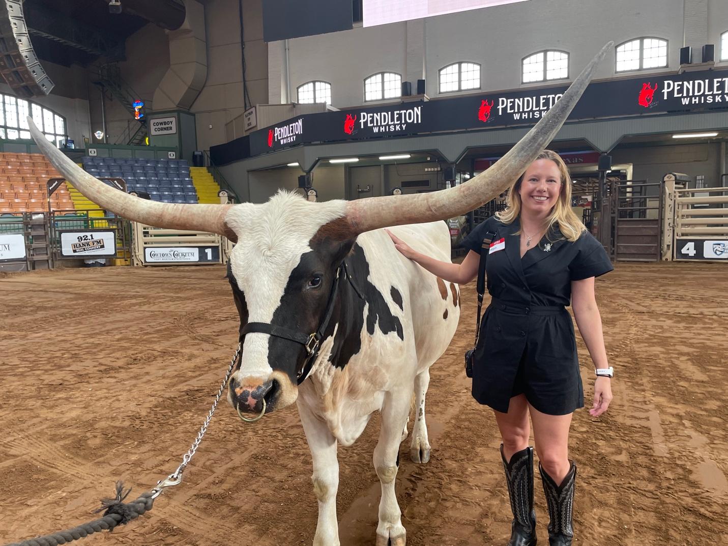 A person standing next to a cow

Description automatically generated