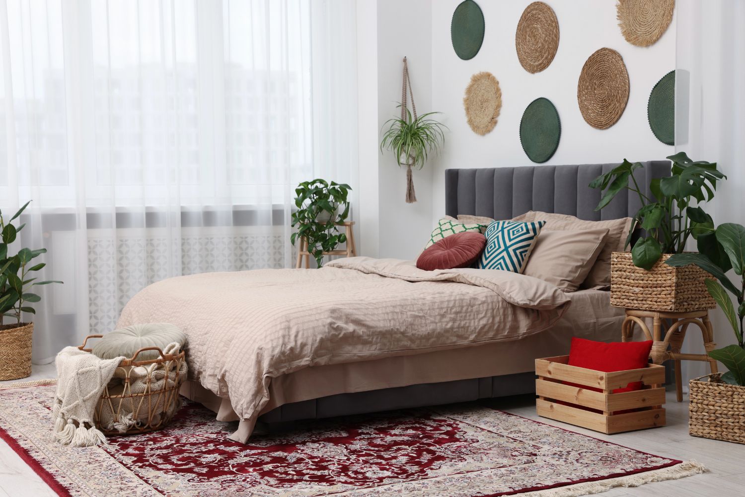 bohemian bedroom with macrame plant hanger, woven wall decor, baskets, and red rug