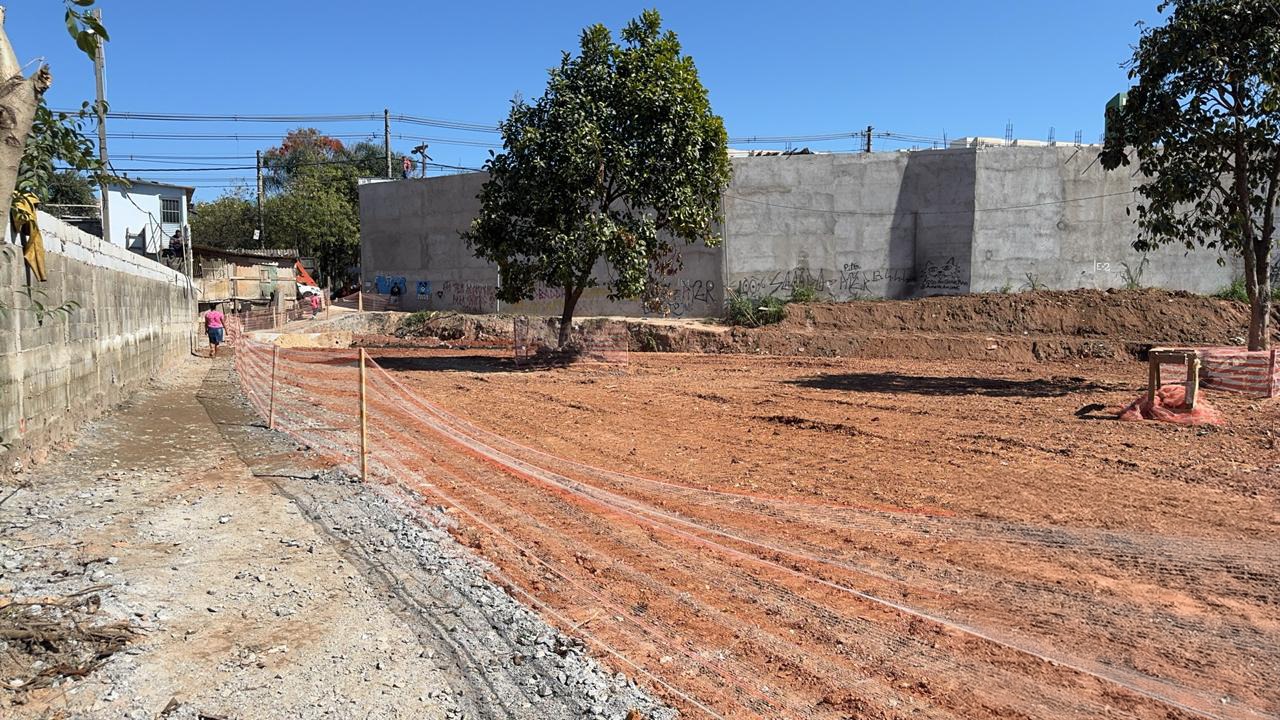 A foto em plano aberta mostra o local em reforma, ainda sem concretagem no chão. O dia está ensolarado e ao fundo é possível ver uma foto