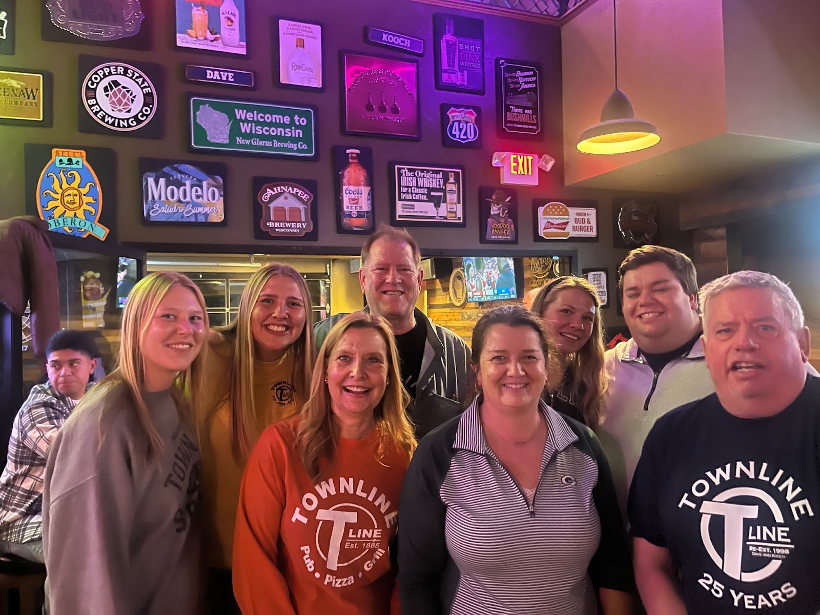 A family in Townline Pub & Grill  posing with the beer selection posters.