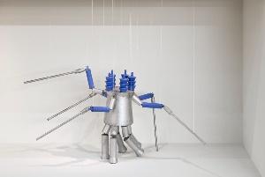 A metal spider with long legs and blue handles

Description automatically generated