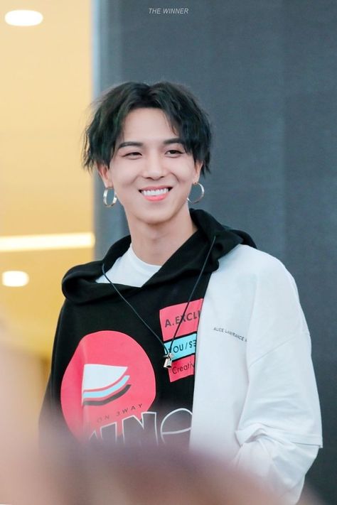 This contains an image of WINNER Mino  smiling while wearing a black hoodie and earring necklaces