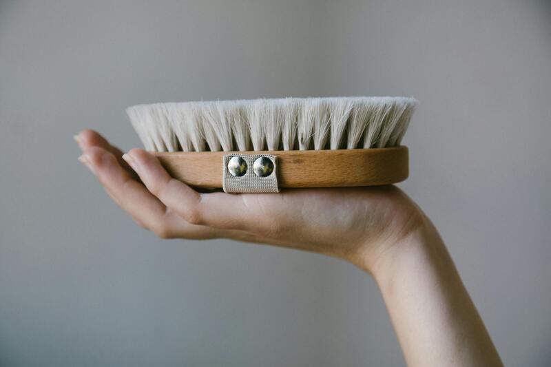 A person holding a shoe brush.