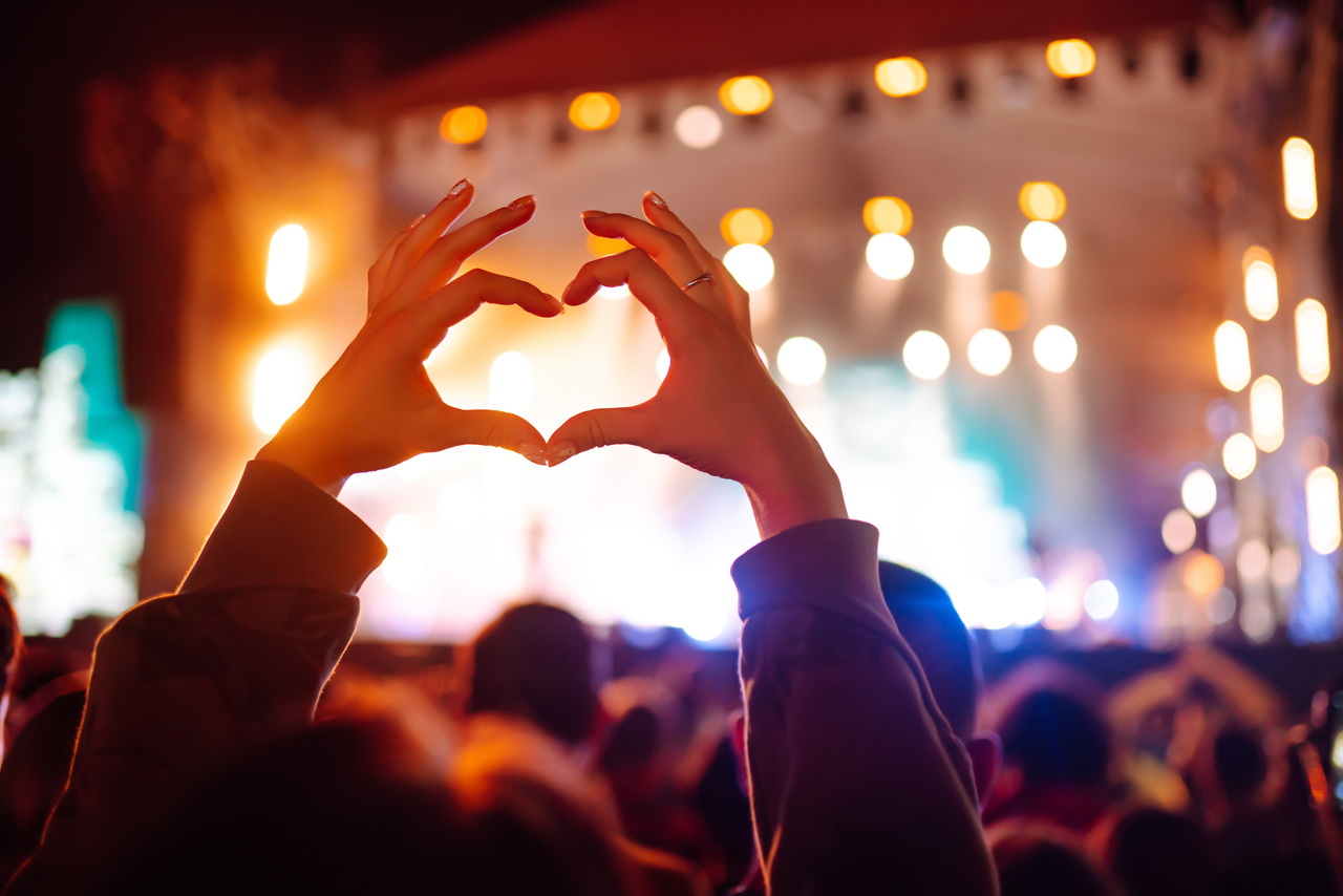 A woman showing a heart sign at a West End Live programme.