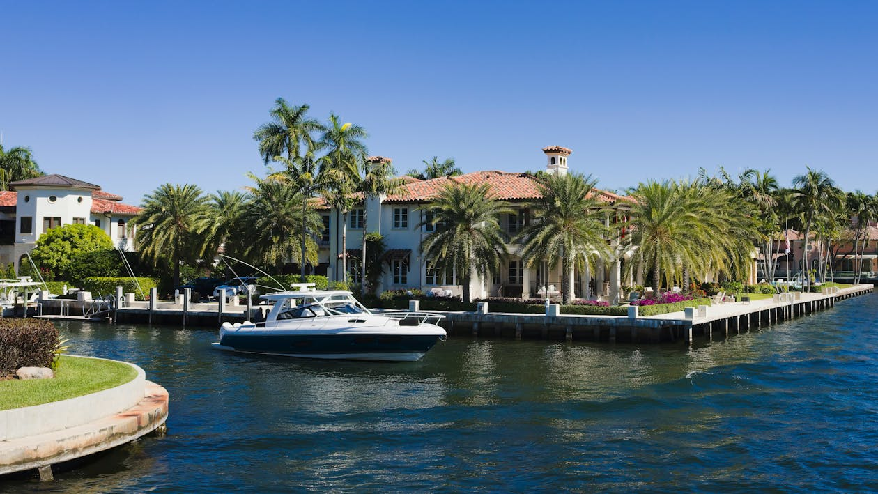 view of boats on a river near the palm trees and mansions in fort lauderdale florida