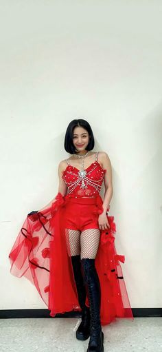 This is a picture of TWICE's Jihyo wearing a red dress with a black shoe